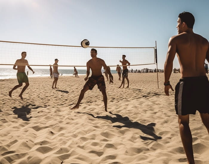 משחק כדור עף על חוף הים בשמש היוקדת